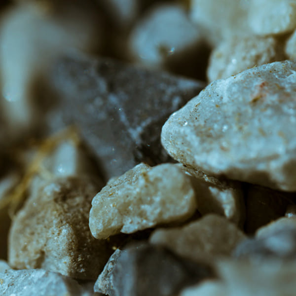 Gros plan sur des fragments de roche et de pyrite utilisés comme remblai sous une fondation